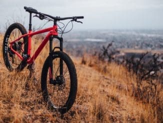 red and black hardtail mountain bike on brown grass field