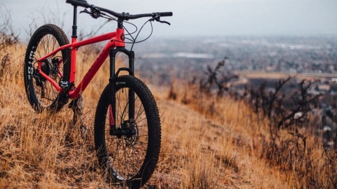 red and black hardtail mountain bike on brown grass field