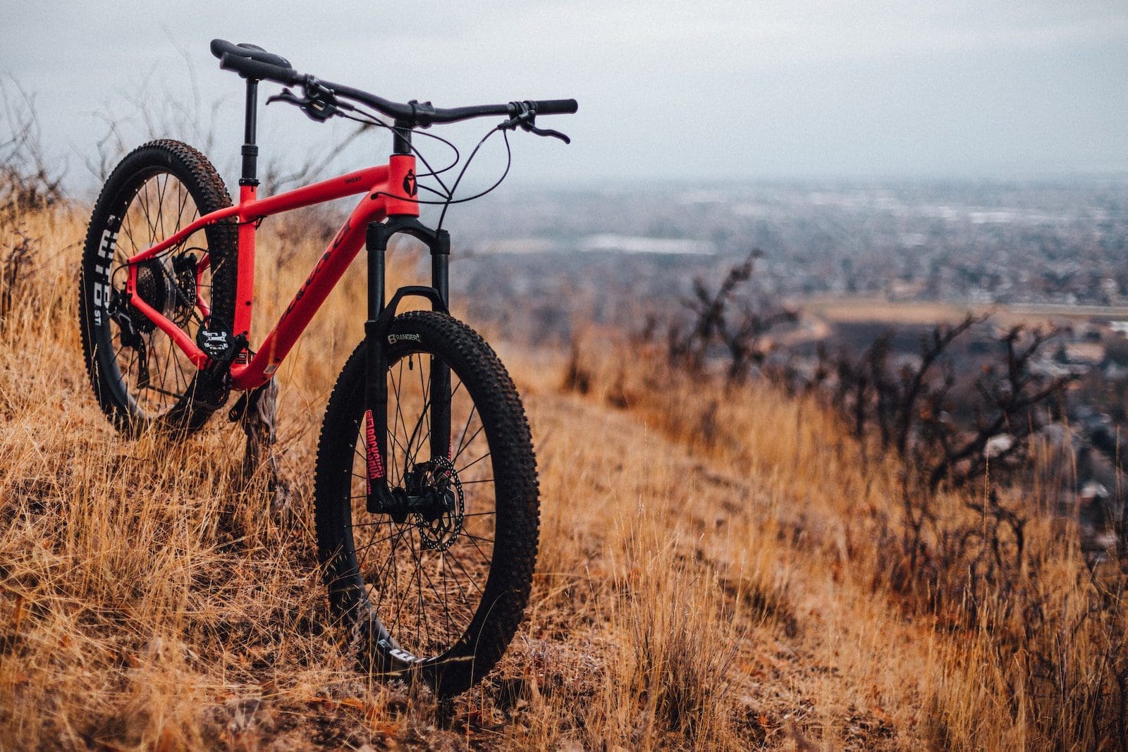 red and black hardtail mountain bike on brown grass field