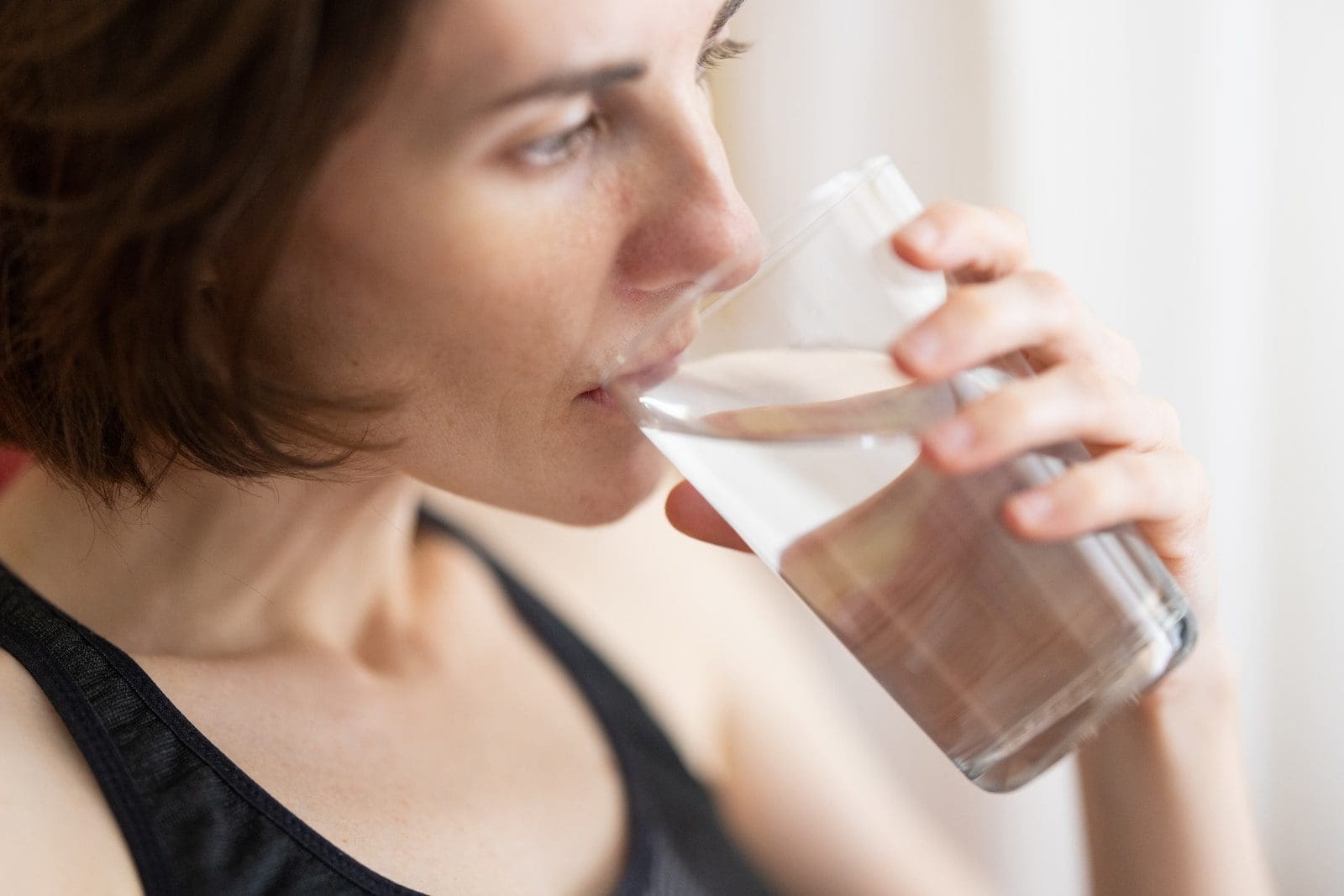 10 Ways To Get Rid Of Swollen Ankles 2 woman in black tank top drinking water