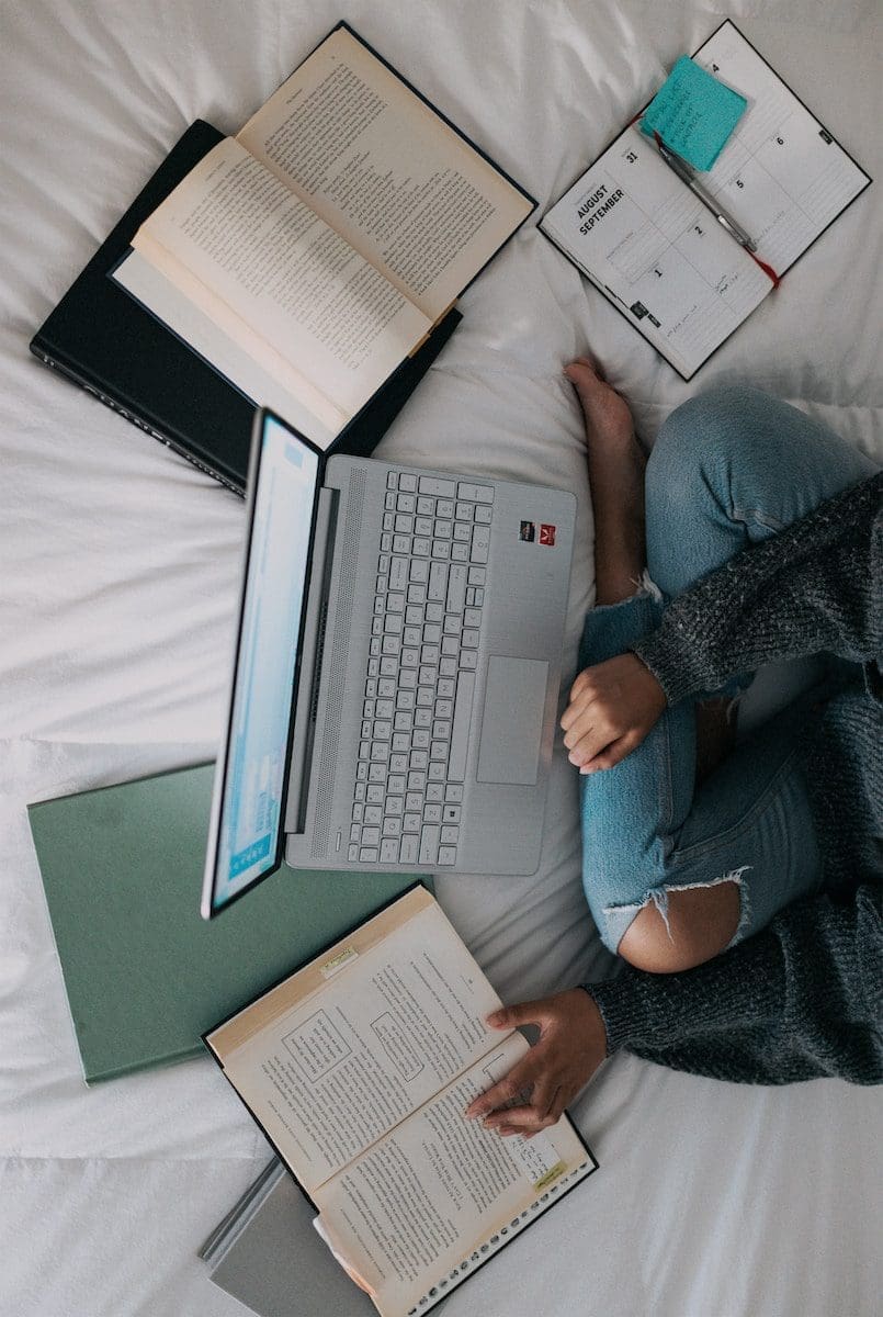 5 Best Educational Search Engines College Students Should Use 1 woman in blue long sleeve shirt and blue denim jeans sitting on bed using laptop