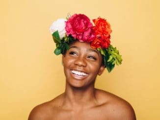 woman smiling wearing flower crown glowing skin