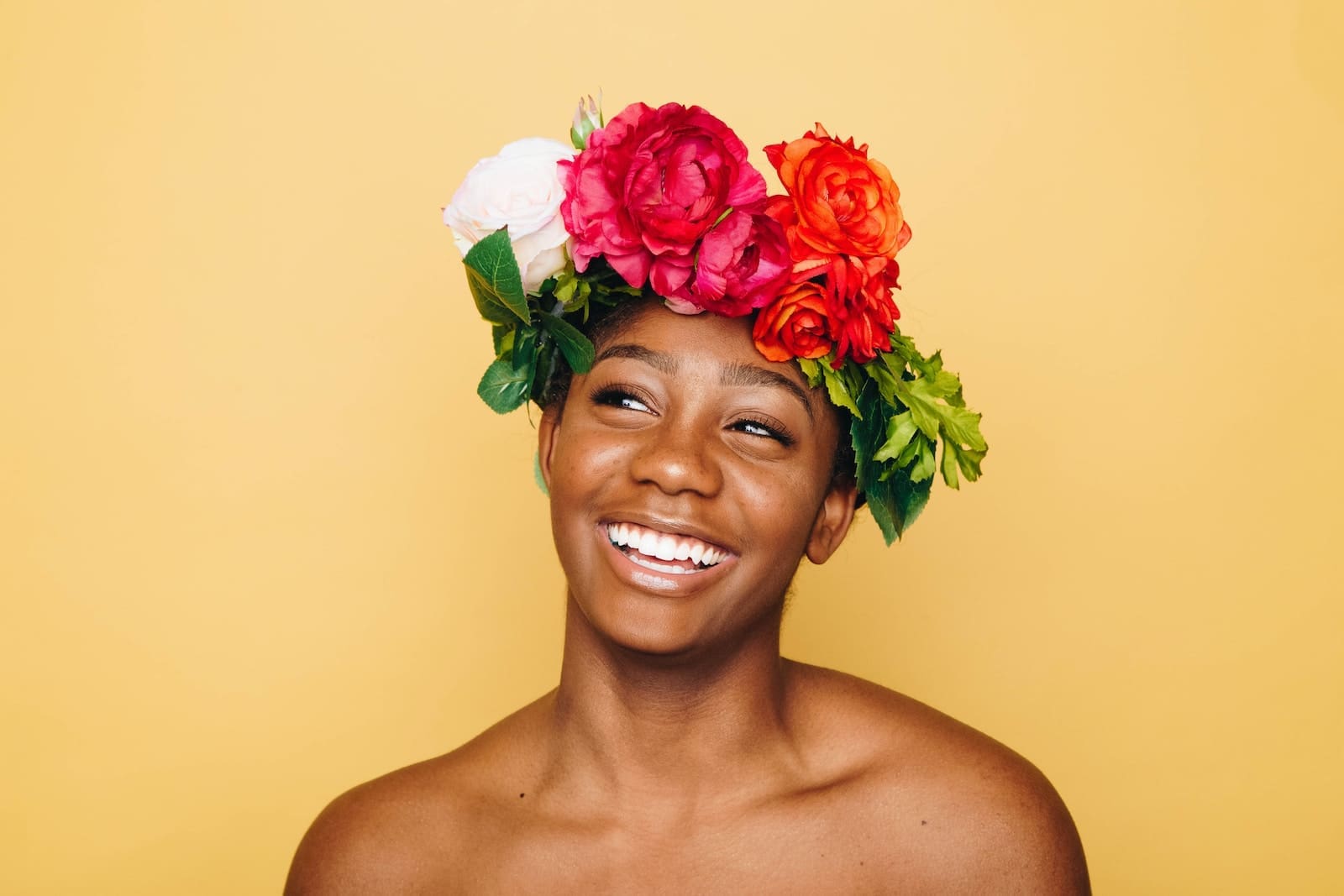 woman smiling wearing flower crown glowing skin