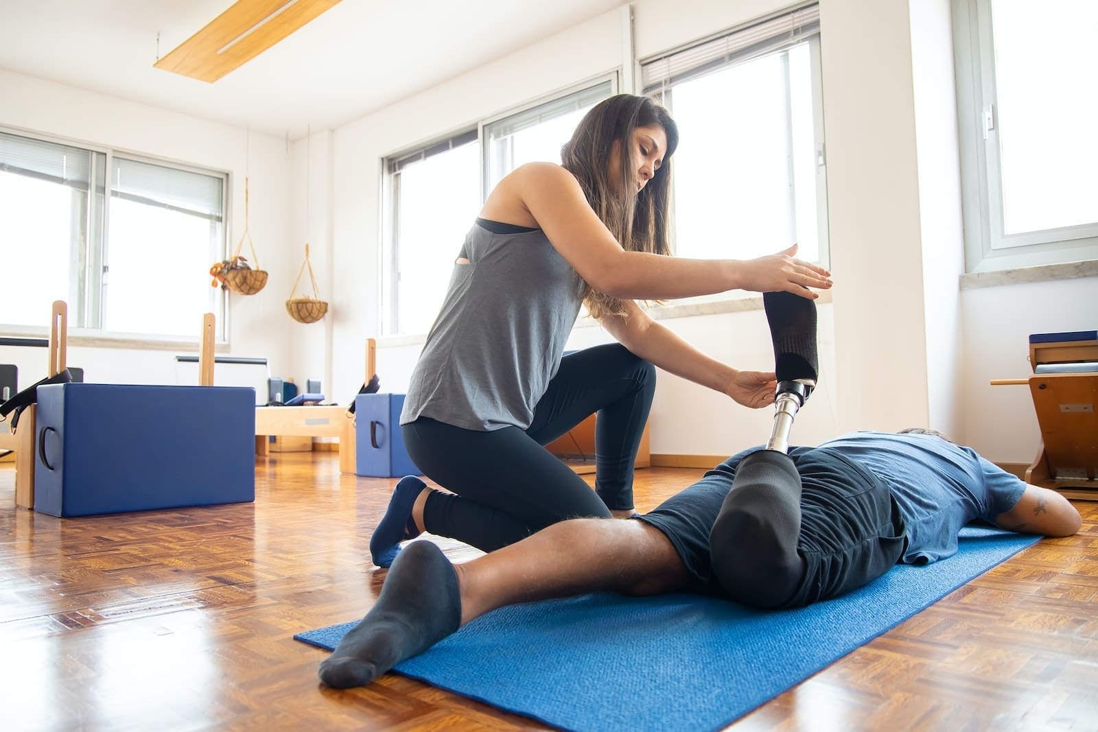 Woman in Gray Tank Top and Black Leggings Doing Yoga