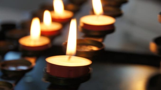 Photo by Eli Solitas lighted candles on black metal candle holder