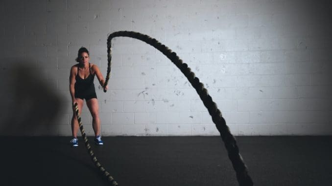 woman holding brown ropes cardio