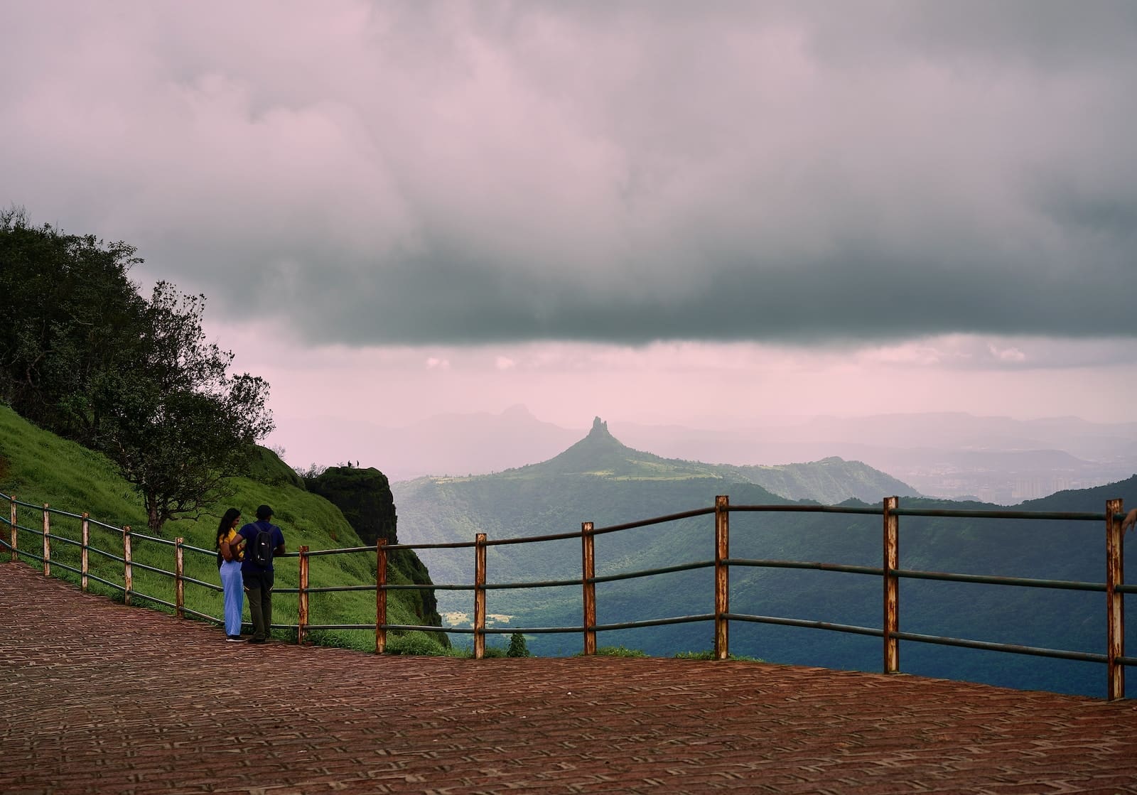 Five Weekend Getaways From Pune To Explore With Your Flatmate 2 a couple of people standing on top of a lush green hillside