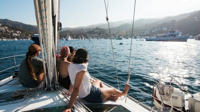people sitting on front of yacht sailing vaction