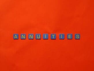 Conceptual image of the word annuity 'Annuities' spelled with tiles on a vibrant red background.