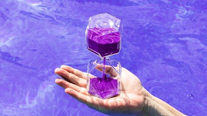 a person's hand holding a bottle of water water level