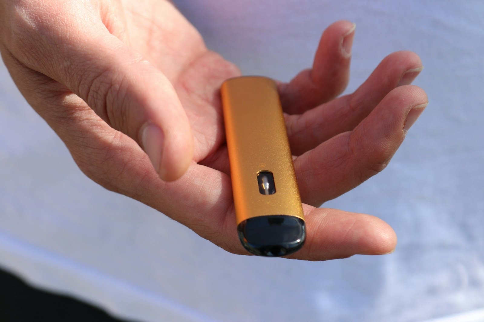a person holding a cell phone vaping device
