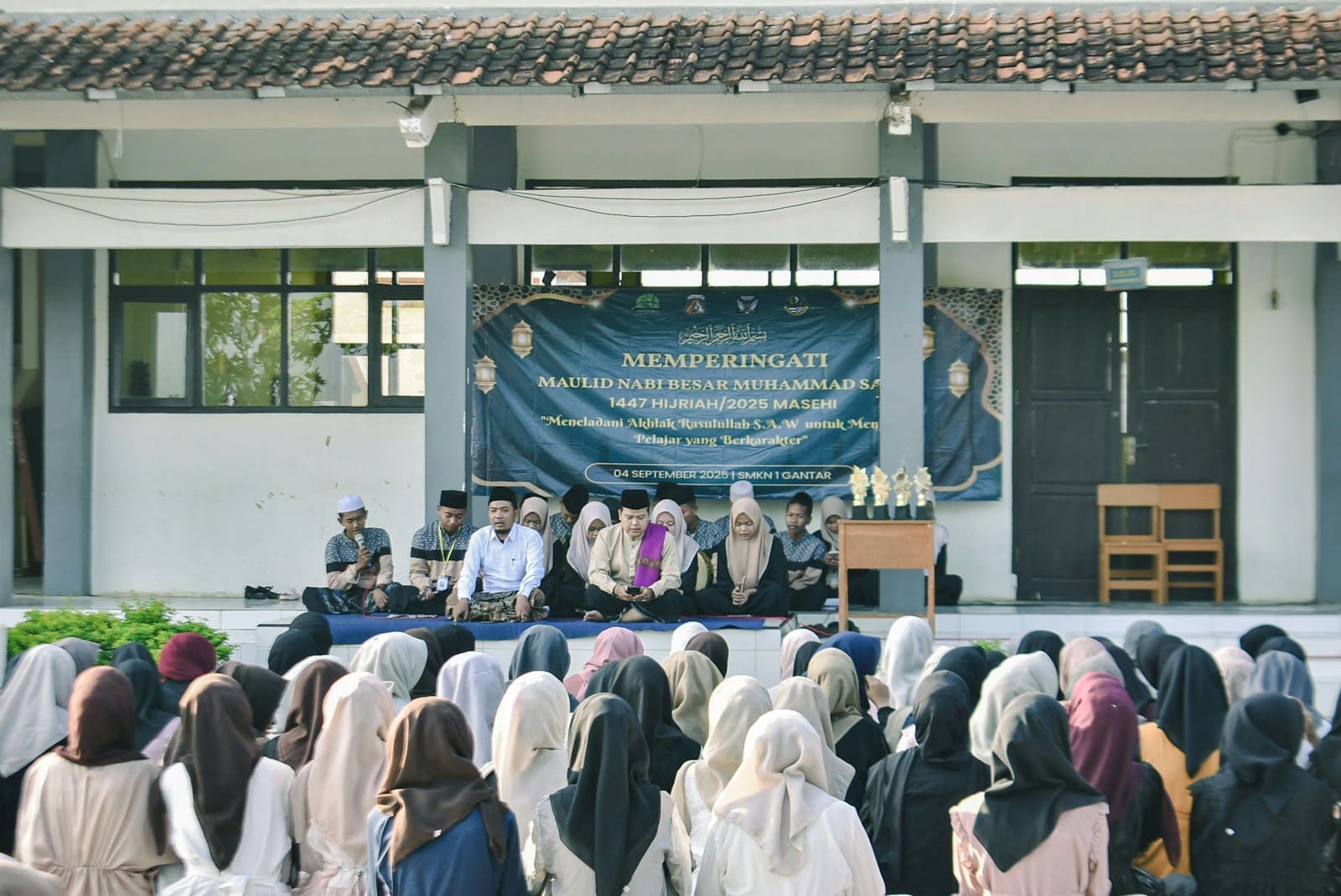 Group of people attending an outdoor event on a stage.